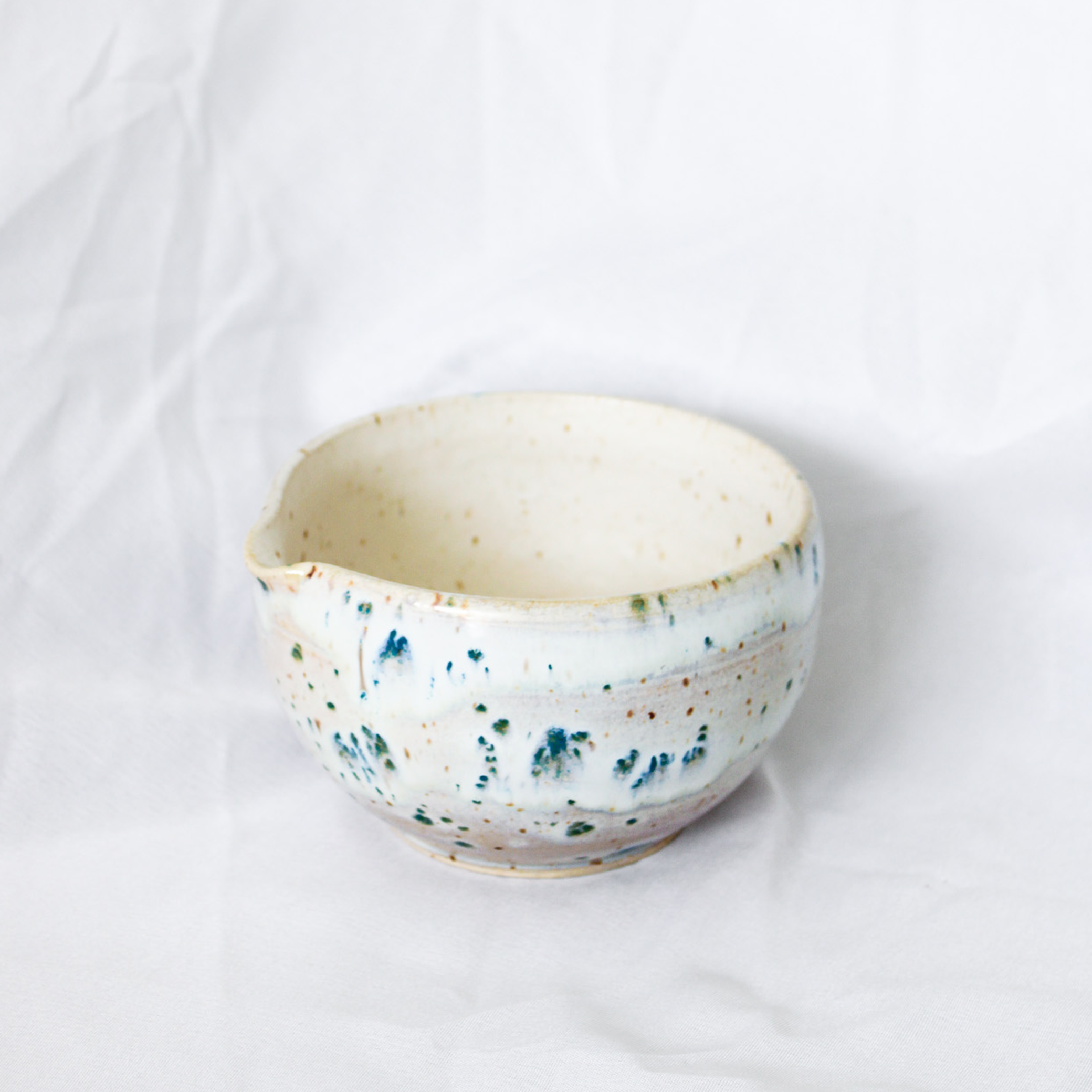 Ceramic bowl with speckled design on a white background
