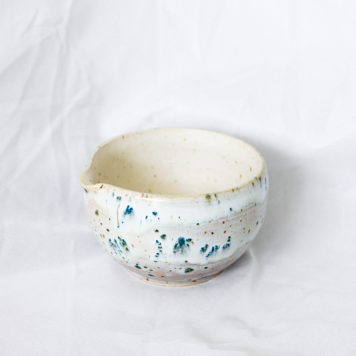 Ceramic bowl with speckled design on a white background
