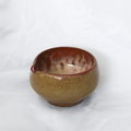 Ceramic bowl with a speckled brown and red design on a white background
