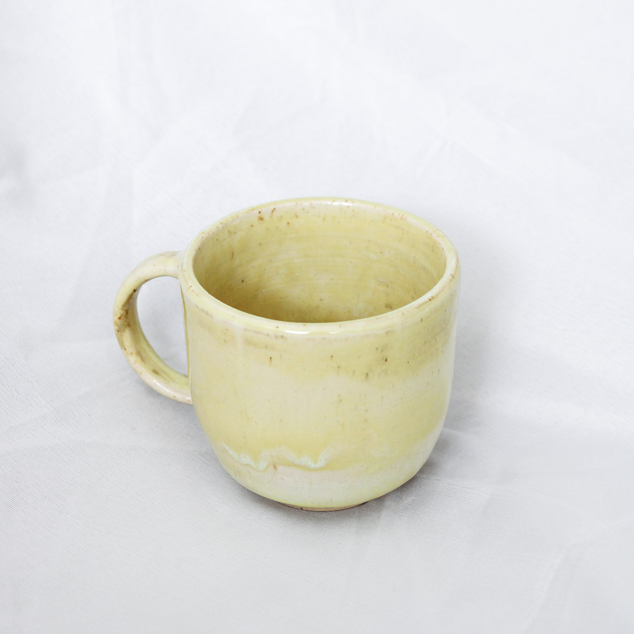 Yellow ceramic mug on a white background