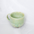 Green ceramic mug on a white background