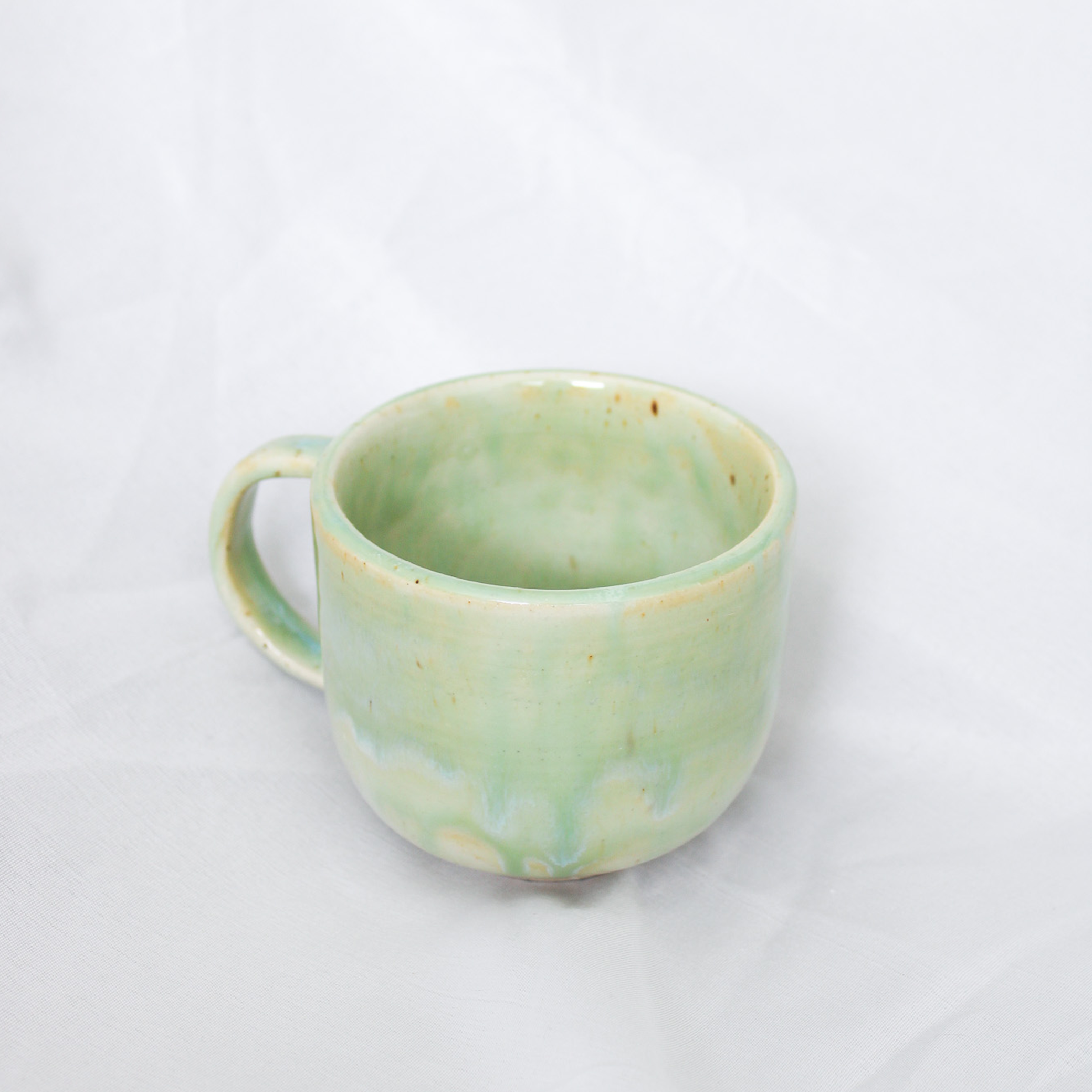 Green ceramic mug on a white background