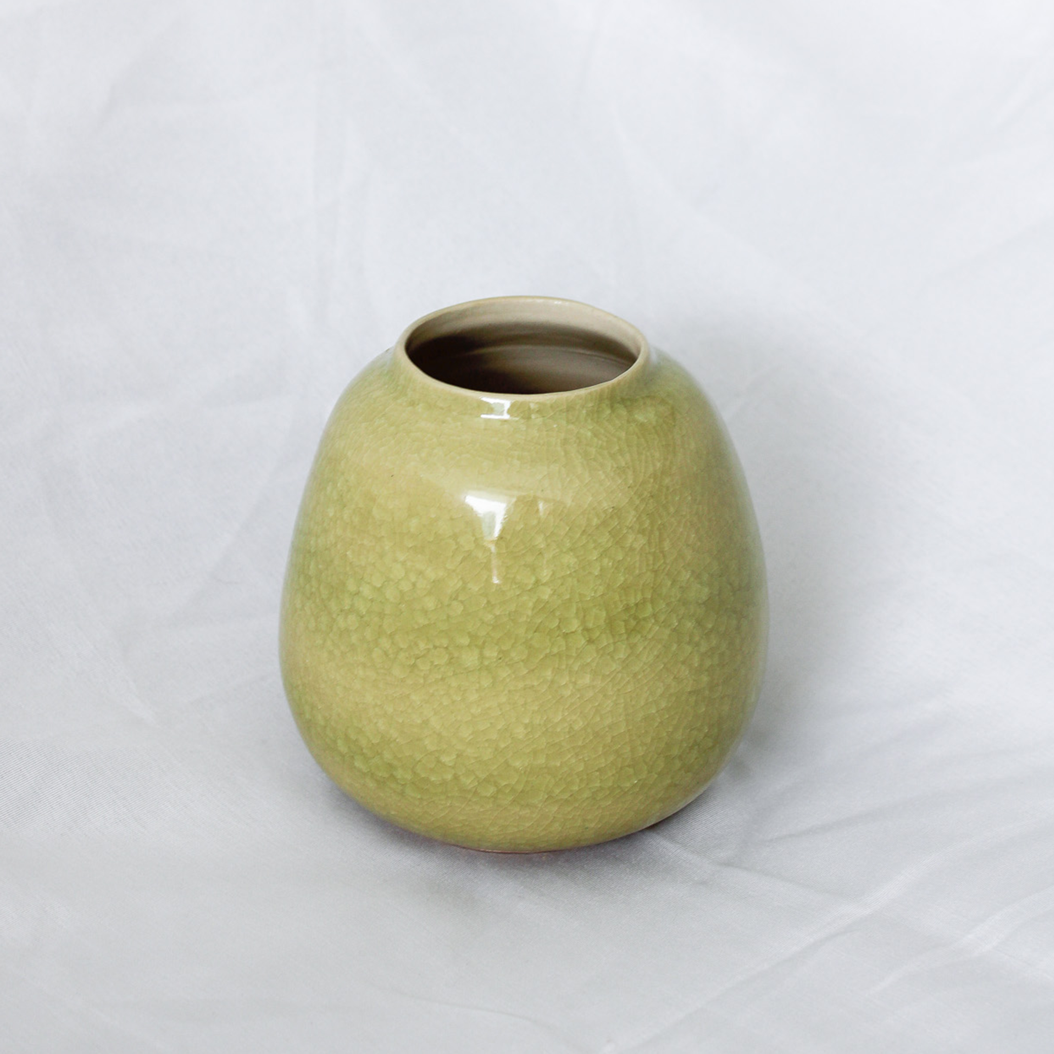 Green ceramic vase on a white background